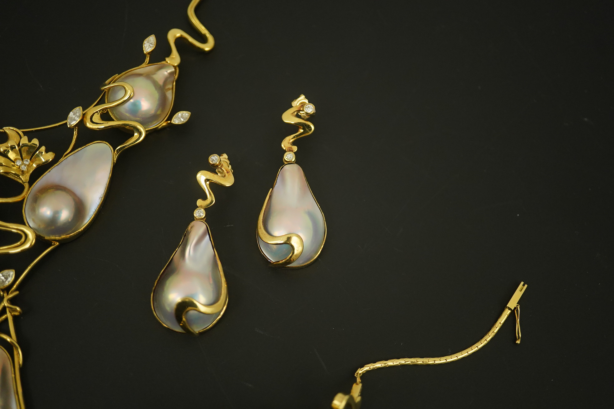 A modern suite of 18k gold, baroque pear, round and marquise diamond set jewellery